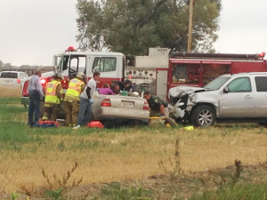 Emergency responders, including Worden Volunteer Fire Department personnel, Montana Highway Patrol Trooper Kirk Robbins, and a Yellowstone County sheriff's deputy, cut apart a Honda Accord to remove passenger Zackery Kirkpatrick. (Tana McNiven photo)