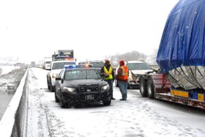 Montana Highway Patrol Trooper and others visiting while all traffic stops until the wreckage is moved off the Interstate. Traffic was down to one lane on the Yellowstone River bridge. (Jonathan McNiven photo)