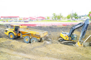 Crews move dirt to prepare to install underground water tanks at the site of the new Splish Splash Car Wash. MetraPark is visible just to the south.